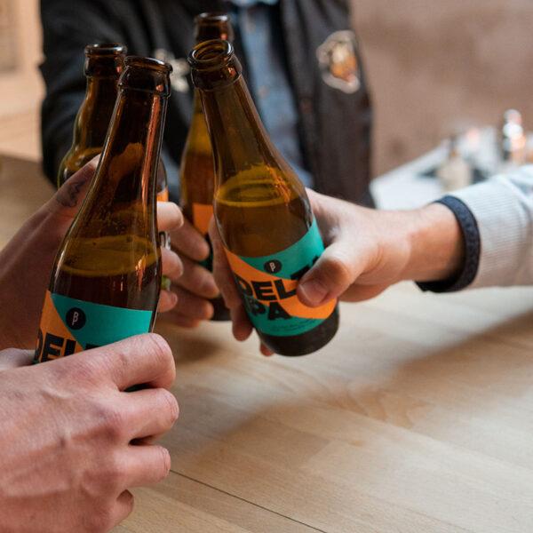 Groupe de personnes trinquant une bière à la main à l'occasion de leur teambuilding